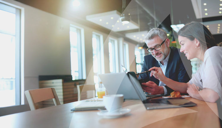 Mann und Frau arbeiten an ihren Laptops in einem Café.