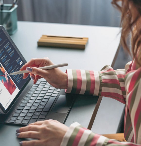 Person mit gestreiftem Hemd, die einen Stylus mit ihrem Tablet benutzt