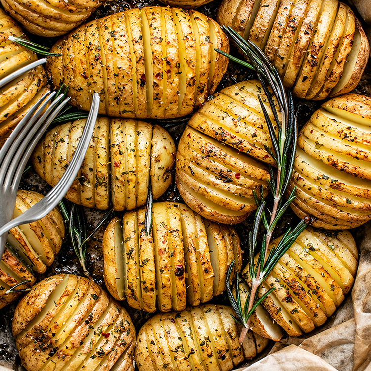 Roasted Hasselback potatoes with rosemary, representing potato price and supply trends in Ireland.
