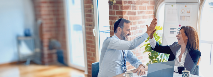 Colleagues high-fiving each other in an office