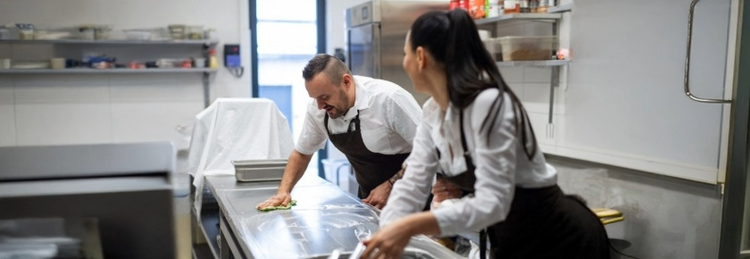 Chefs cleaning the kitchen counter