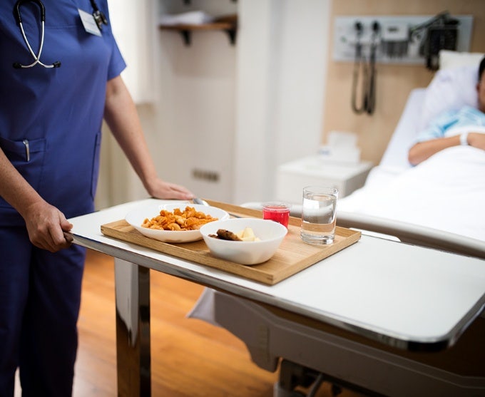 Medical professional delivering a meal to a patient