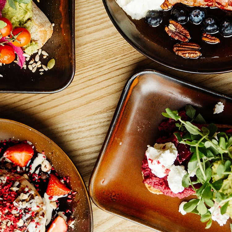 A table featuring four plates of food