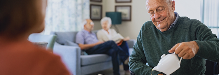 Care home resident having tea in a communal lounge, highlighting quality care and hospitality services