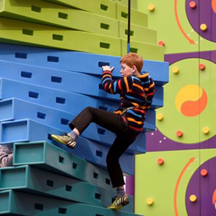 A boy climbs a climbing wall