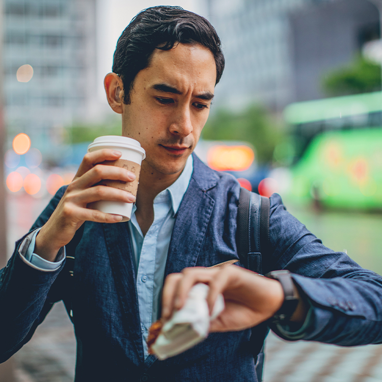 Commuter with takeaway coffee and wrapped food illustrating convenient grab-and-go dining