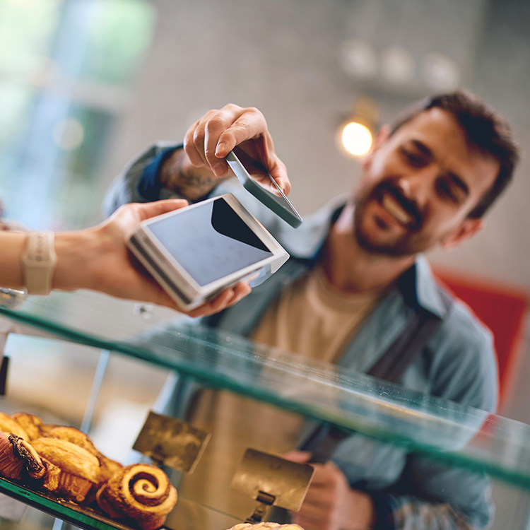 Customer making a contactless payment for grab-and-go food at a foodservice counter