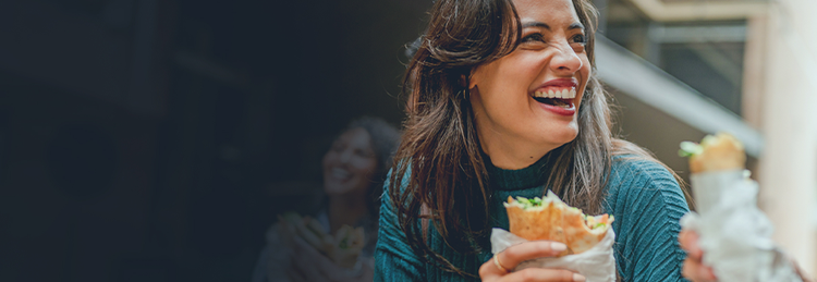 Customer enjoying a fresh grab-and-go wrap in a casual dining setting
