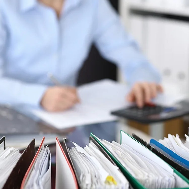 A woman diligently reviews paperwork