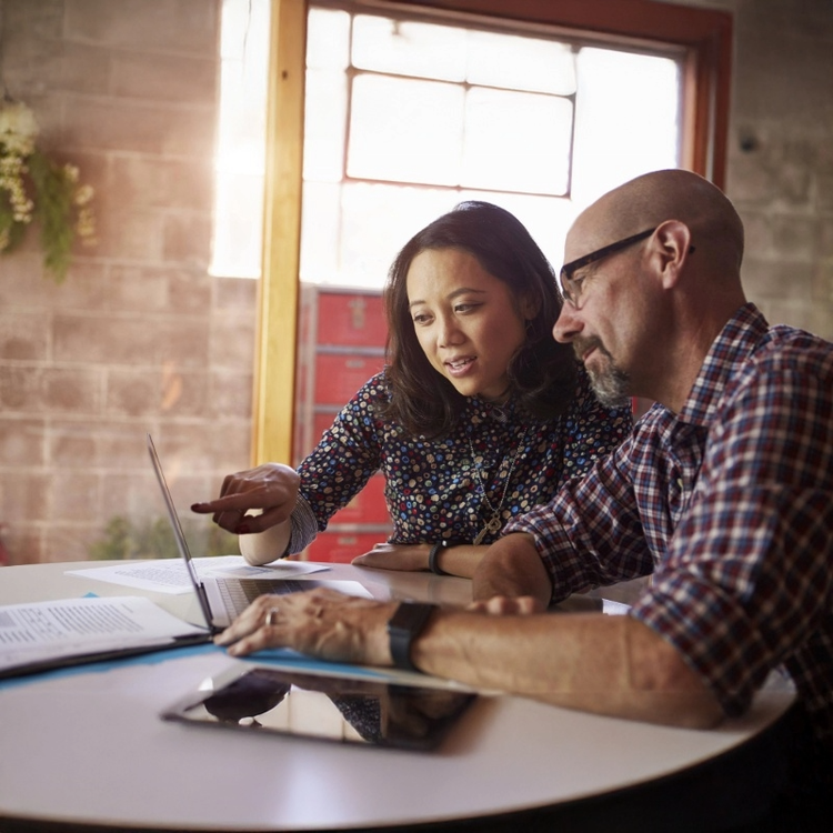 A man and woman engage with a laptop