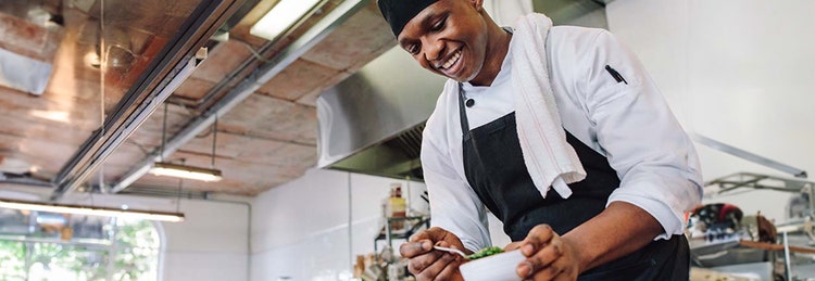 A chef skillfully prepares ingredients in a kitchen, showcasing culinary expertise and attention to detail.