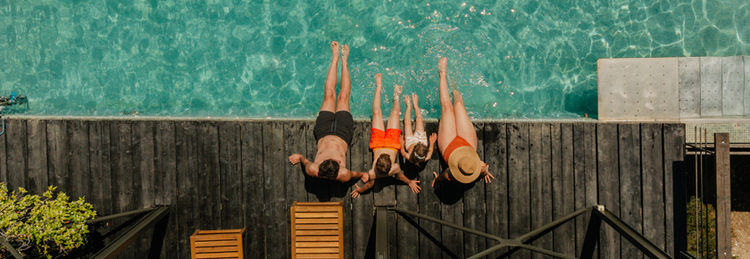 family sitting at edge of luxury pool