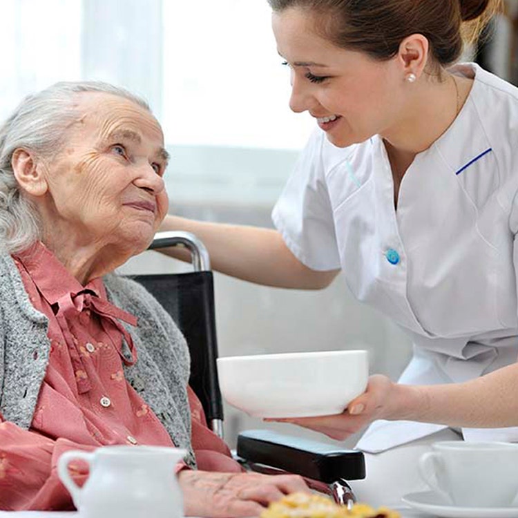 A carer serving an elderly woman