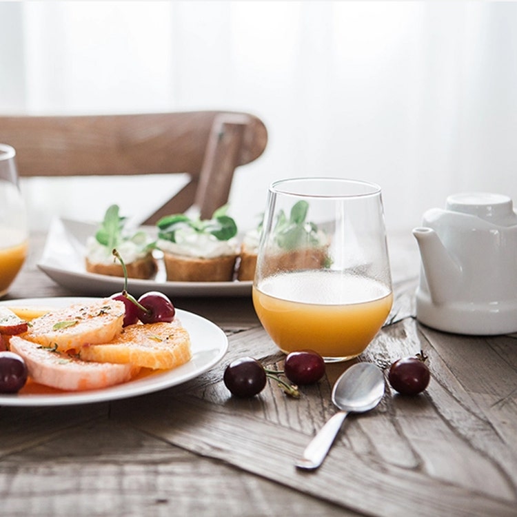 A table set with food and a glass of orange juice.