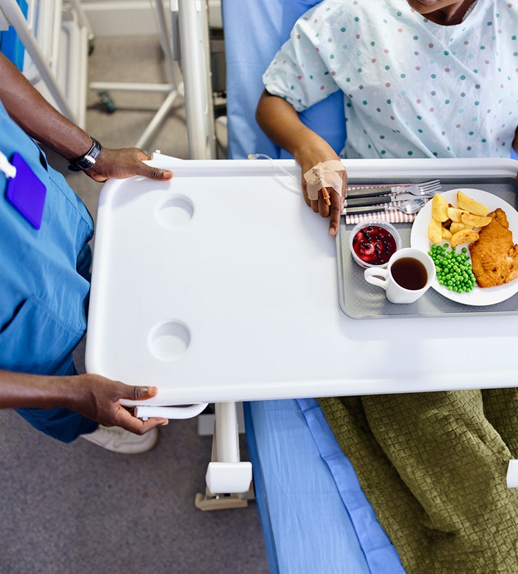 Medical professional delivering a meal to a patient