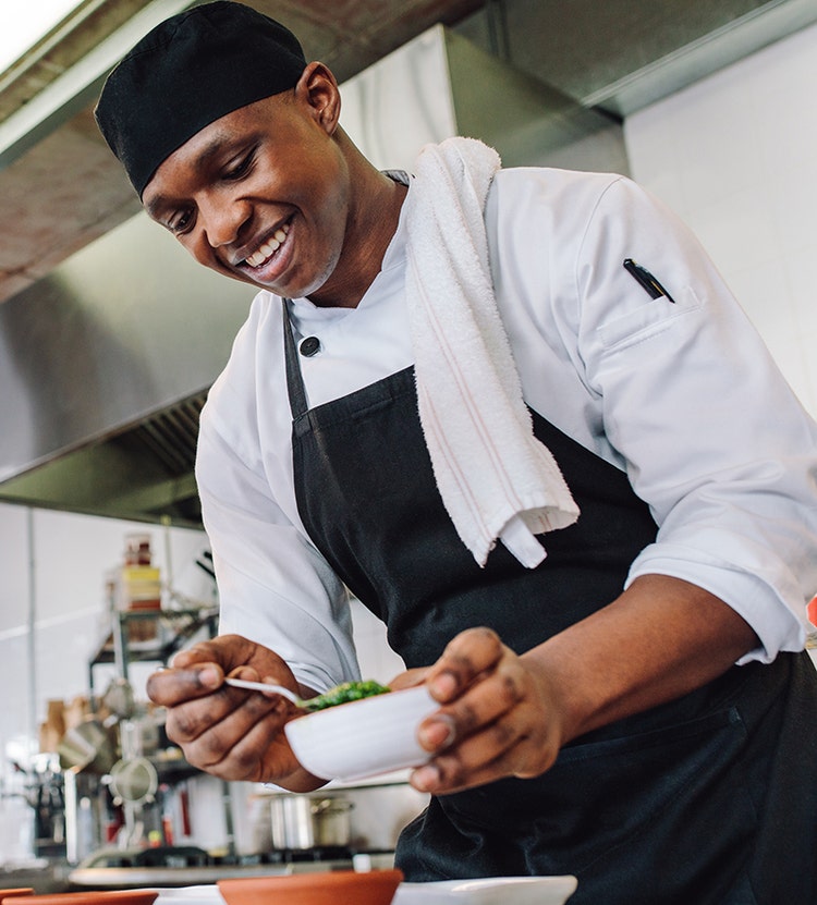 Chef preparing a small dish in a commercial kitchen