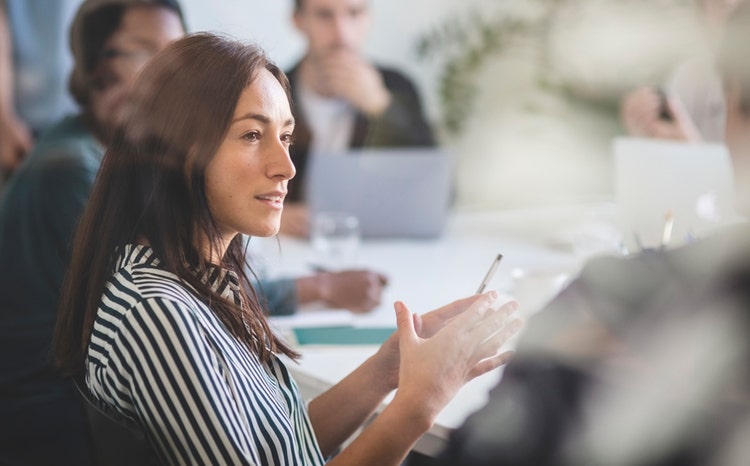 Businesswoman explaining to colleagues during a meeting at Avendra International, collaborative team and professional expertise