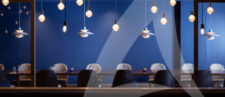 A long table in a meeting room with a solid blue wall in the background.