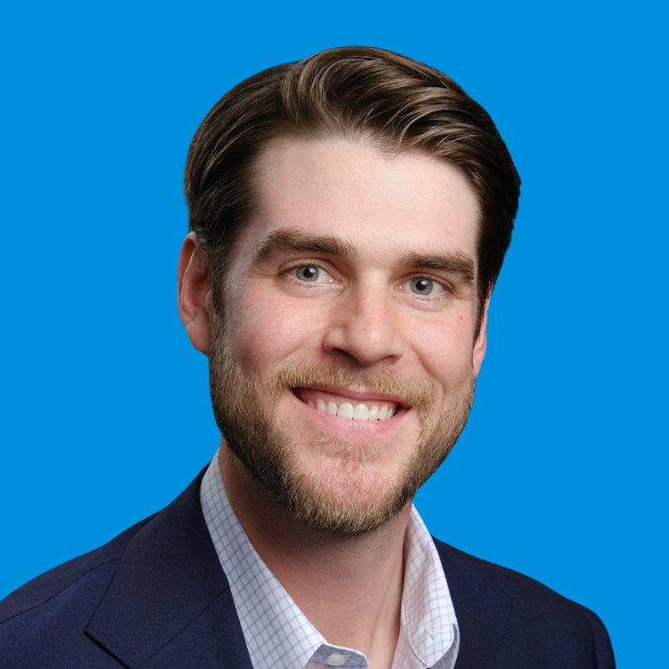A professional headshot of Sean Whalen with a blue background