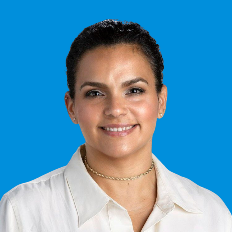 A professional headshot of Mercedes Rodriguez with a blue background