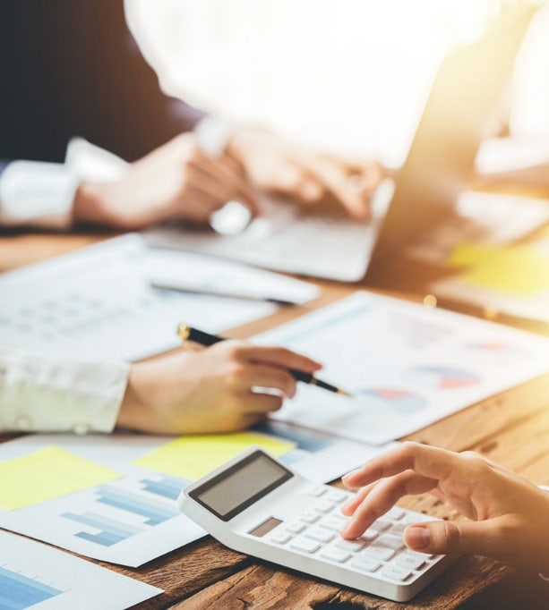 Business team analyzing price charts and discussing strategies, showcasing Avendra International's expertise in price analytics and strategic consultancy for the hospitality industry.