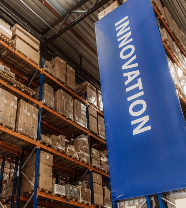 Busy warehouse dispatch center with workers organizing packages, emphasizing Avendra International's efficient supply chain management solutions.