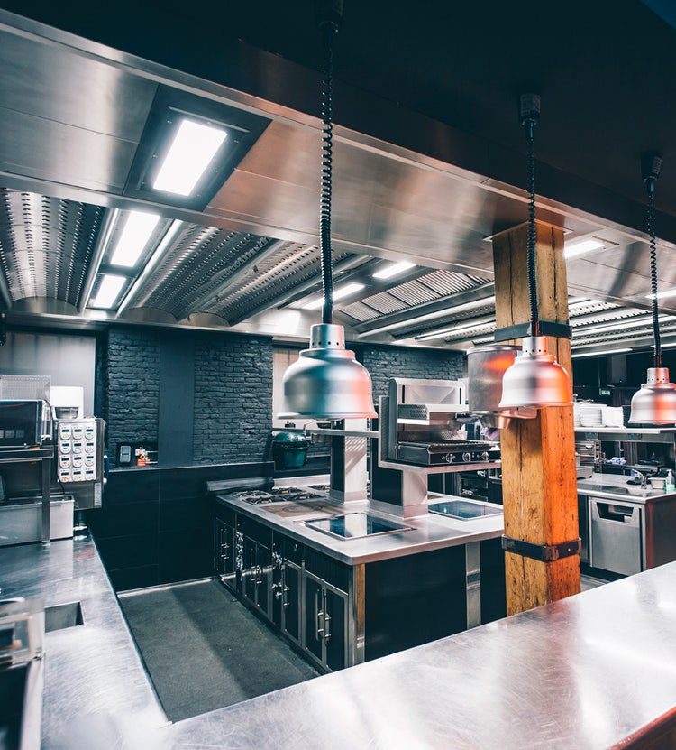 Interior of an illuminated commercial kitchen with decorative furnishings at an Avendra International hotel, hospitality procurement