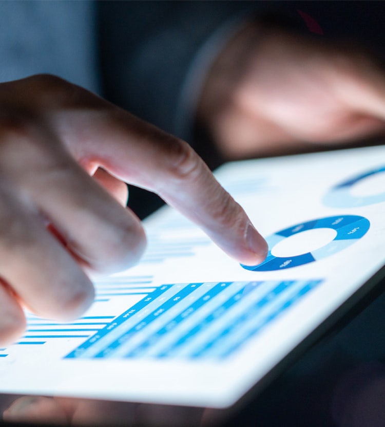 Business report on a digital tablet at Avendra International, profit analysis and financial planning