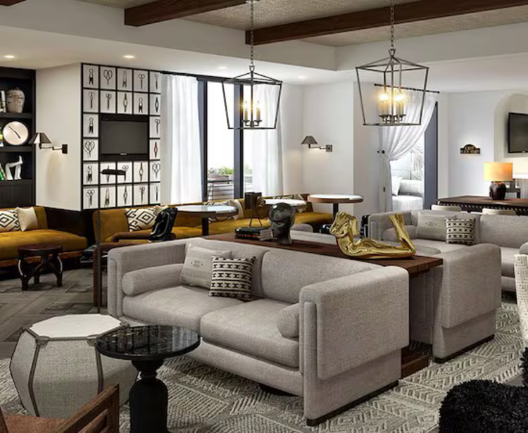 A cozy living room with modern furniture, artwork, and pendant lights.