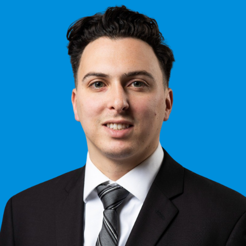 A professional headshot of Mike Tosti with a blue background