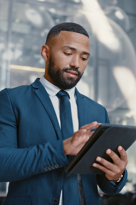 Hotel manager and man using a digital tablet for hospitality services at Avendra International, digital solutions in hospitality