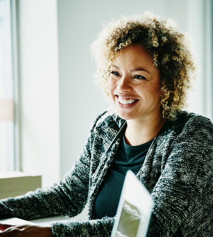 Smiling businesswoman in a meeting with clients discussing financial services at Avendra International, procurement solutions