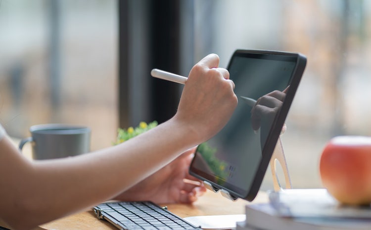 Side view of office worker working with a computer or iPad in hospitality at Avendra International, digital tools in hospitality