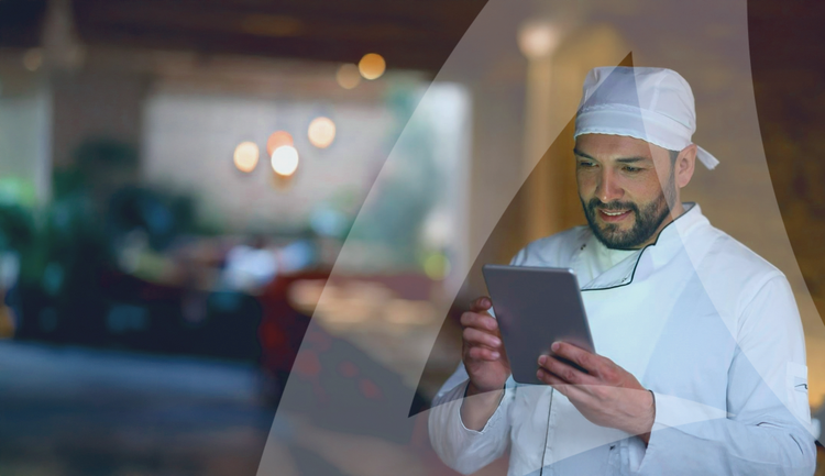 Chef looking at and holding a tablet.