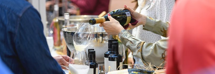 Person holding wine glass as other person fills glass for a wine tasting