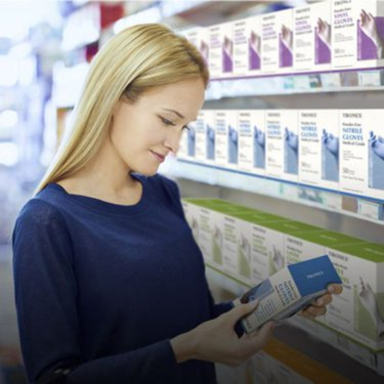 Woman looking down at plastic gloves in store