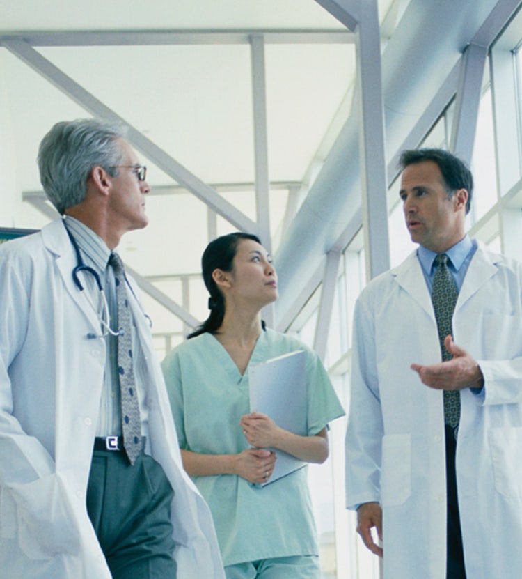 Medical personnel walking down a hospital corridor, highlighting Avendra International's healthcare procurement services and commitment to quality patient care.