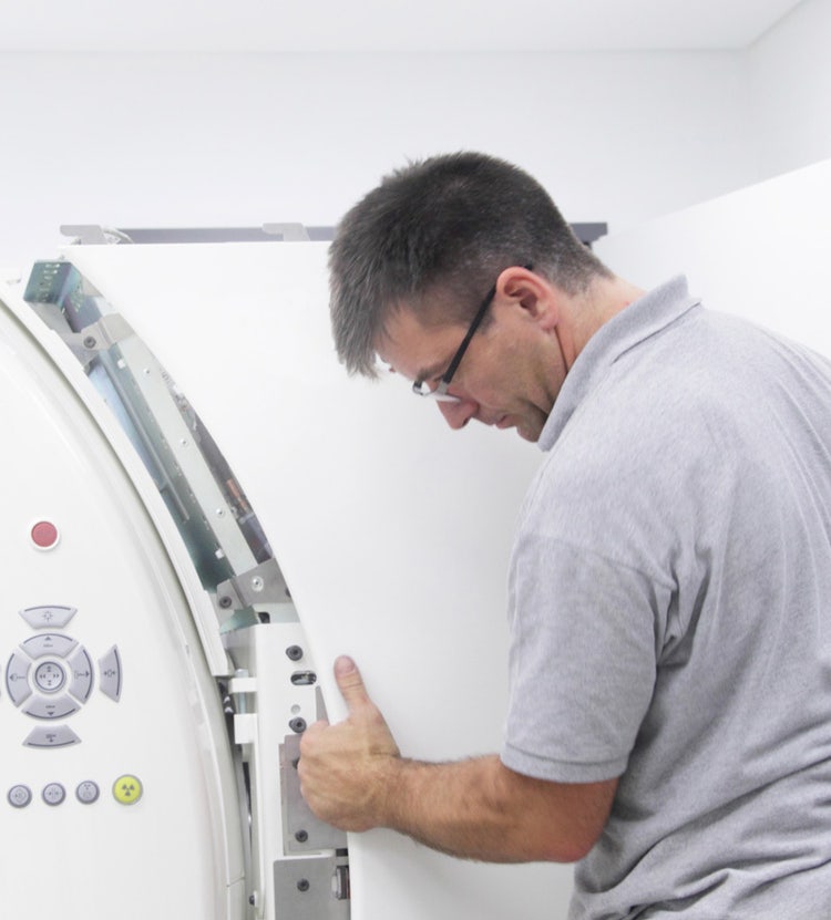 Worker examining medical equipment in a hospital, highlighting Avendra International's expertise in hospital maintenance and procurement solutions.