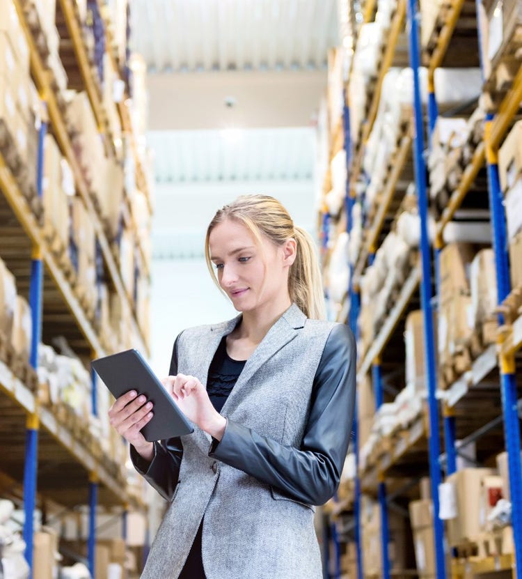 Businesswoman working on tablet in warehouse - Avendra International's efficient warehouse organization