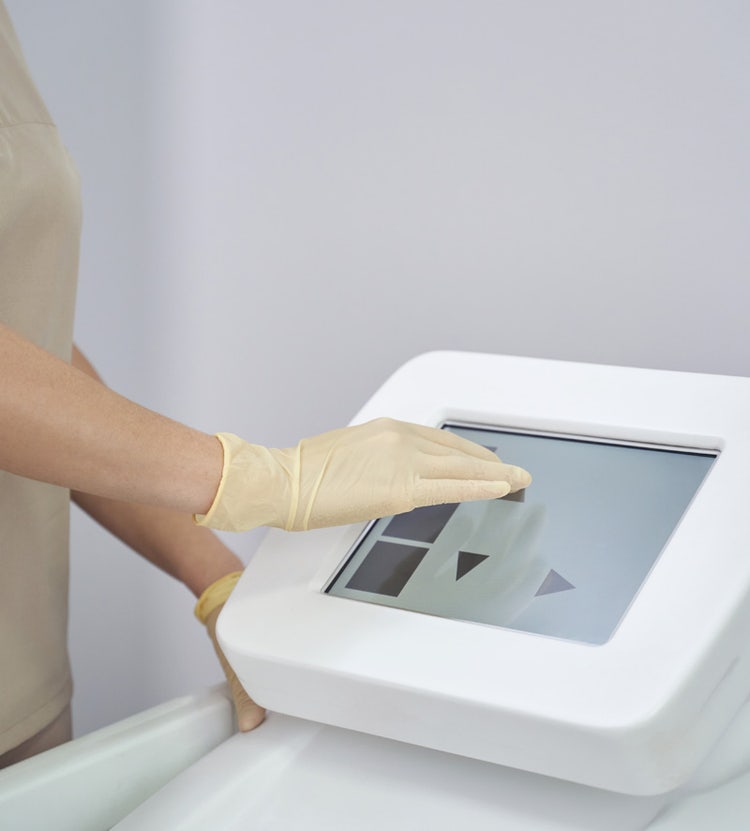 Person operating touchscreen on advanced medical equipment, highlighting Avendra International's commitment to innovation and advanced technology in hospitals.