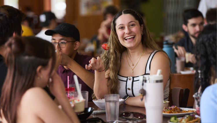 A group of people enjoying a meal at a restaurant, with various food items and drinks on the table. A lively and social dining scene.