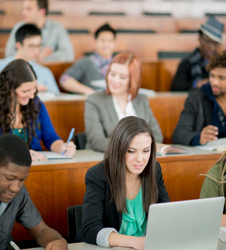 Student taking notes on a laptop in a classroom, highlighting Avendra International's educational procurement solutions for colleges and universities.