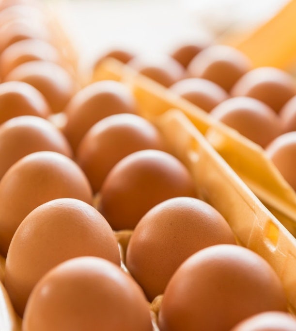 Primer plano de cartones de huevos en una cocina comercial, en el que se destacan las fiables soluciones de Avendra International para la cadena de suministro de la industria alimentaria.