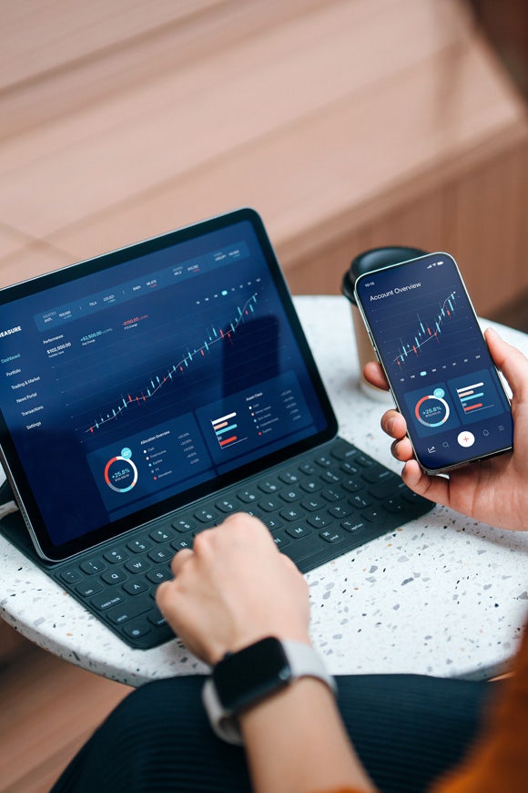 Vista por encima del hombro de una mujer de negocios utilizando un ordenador o un iPad en el sector de la hostelería en Avendra International, tecnología en hostelería