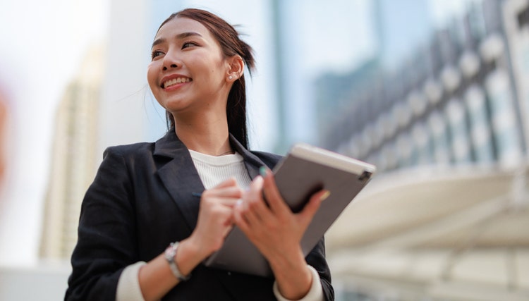 Mujer de negocios segura de sí misma elaborando estrategias con sus colegas en Avendra International, oportunidades de carrera para jóvenes profesionales.