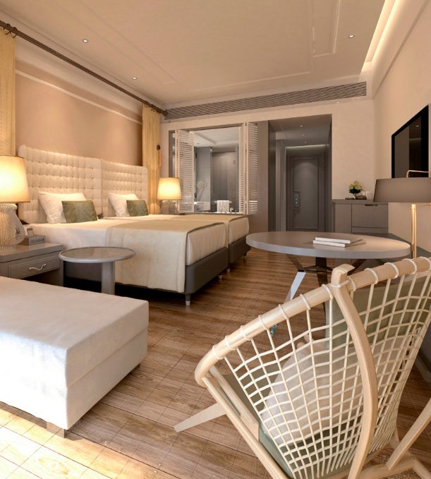 Chambre d'hôtel moderne et luxueuse avec un mobilier élégant et une vue imprenable sur l'océan, mettant en valeur les solutions d'accueil haut de gamme d'Avendra International.