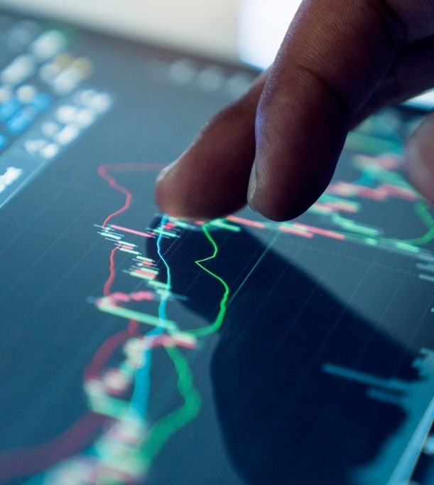Analyste de marché examinant des données sur un écran numérique, faisant la promotion des services avancés d'analyse de marché et d'approvisionnement stratégique d'Avendra International.