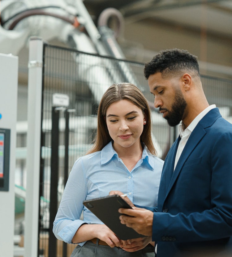 Femme responsable d'entrepôt discutant de logistique avec un collègue chez Avendra International, gestion de la chaîne d'approvisionnement