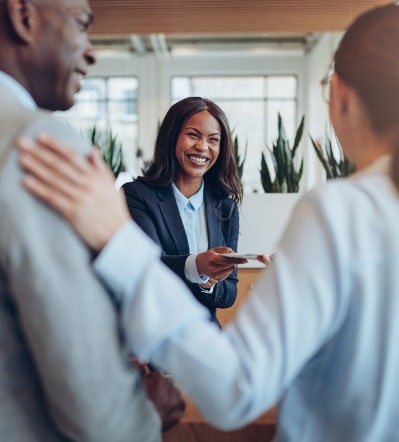 Woman smiling while handing a piece of paper to a colleague