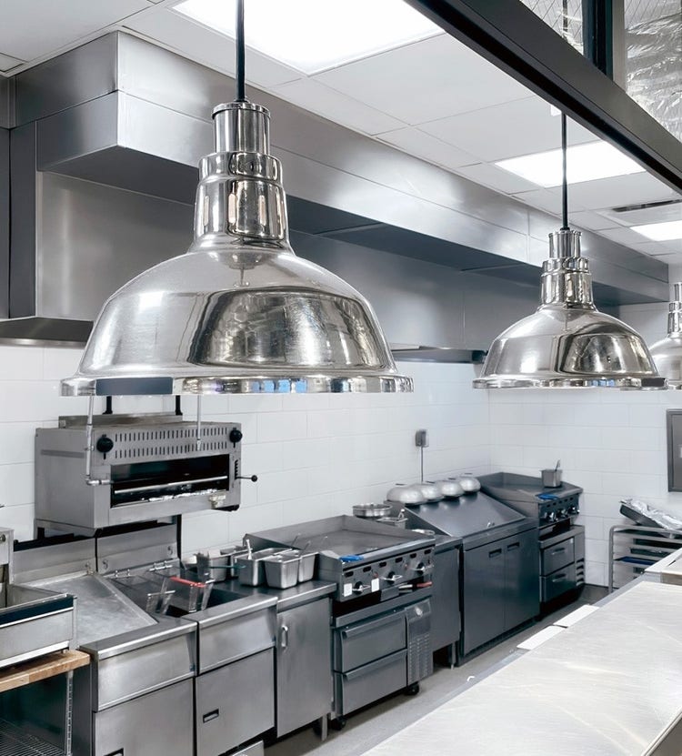 Clean and modern industrial restaurant kitchen, emphasizing Avendra International's premium sourcing solutions for commercial kitchens.